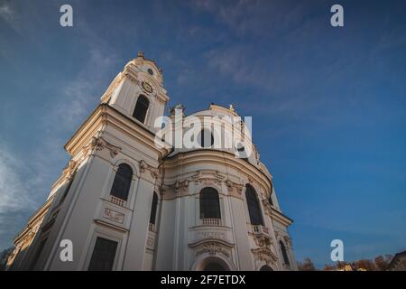 Fassade der kollegienkirche in Salzburg, die an einem trüben, grauen Herbsttag von unten auf einen der Glockentürme blickt. Stockfoto