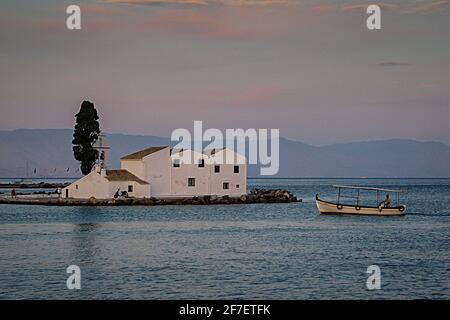 Das Kloster von Panagia Vlachernitissa auf der griechischen Insel Korfu am frühen Abend, mit einem Boot vorbei. Stockfoto