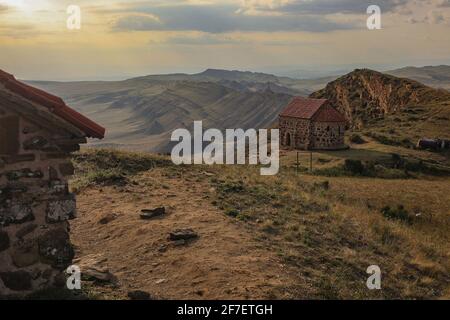 Massiver Garedjian Ridge in Georgia in der Nähe des David Gareji Klosters. Häuser oder Kirchen im Vordergrund. Atemberaubende Aussicht vom David Gareja Kloster Stockfoto