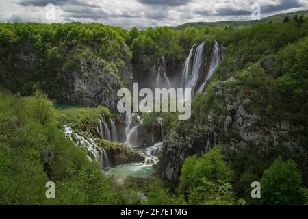 Panoramablick auf den größten Wasserfall namens veliki Slap in plitvicer Seen, kroatien an einem bewölkten Frühlingstag. Großer Wasserfall, umgeben von üppigem Grün Stockfoto