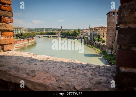 Blick von der Brücke Castel Vecchio in Verona, Italien auf die Brücke Vittoria auf der Etsch an einem sonnigen Tag. Wunderschöne Aussicht über den Fluss. Stockfoto