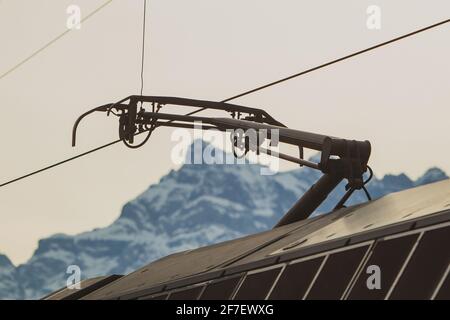 Pantoghraph, das Gerät zur Stromaufnahme von Oberleitungen auf schweizer Bahnen. Im Hintergrund sichtbare Berge in der schweiz. Stockfoto