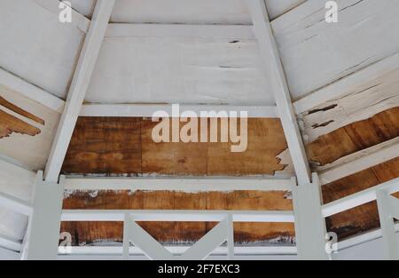 Die Wand, die Decke und das Dach eines beschädigten Holzpavillons werden gerade renoviert Stockfoto