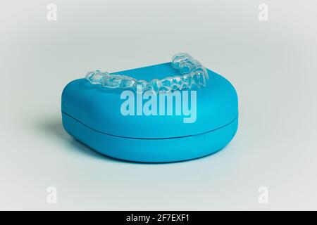 Blaue Tragetasche für kieferorthopädische Halterung aus transparentem Kunststoff, isoliert auf weiß. Halter zum Ausrichten der Zähne. Stockfoto