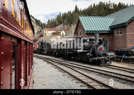 Dampflokomotive der Georgetown Loop Railroad in Colorado, USA. Der Motor steht in einem Depot und schaut von einem anderen Bus aus. Stockfoto