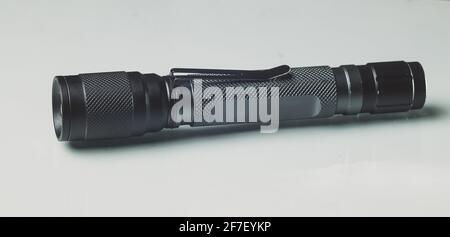 LED-Taschenlampe aus schwarz eloxiertem Metall oder Aluminium. Moderne LED-Handlampe auf weißem Hintergrund. Stockfoto