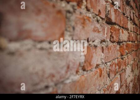 Detail der alten Ziegelwand mit sichtbaren Zementflecken und Resten auf den Ziegel. Rote Backsteinmauer aus der Nähe betrachtet. Stockfoto