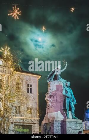Berühmte Preserenstatue in Ljubljana, Slowenien in der Nacht bei festlichem Licht Mitte dezember, mit Vollmond im Hintergrund Stockfoto