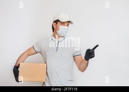 Kurier in medizinischen Gummihandschuhen und Schutzmaske mit Kartons. Lieferservice. Quarantäne. Stockfoto