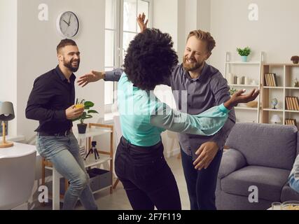 Zwei glückliche junge Menschen lächeln und umarmen sich gegenseitig Sie treffen sich auf der Party von Freunden Stockfoto