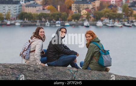 Eine Gruppe von Touristen posiert auf dem Aussichtspunkt Skinnarviksberget, weit über Stockholm. Das Stadtbild von stockholm ist im Hintergrund zu sehen. Stockfoto