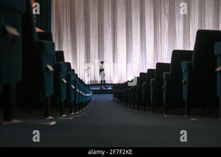 Berlin, Deutschland. März 2021. Mitarbeiter Thore Horch geht durch die leere Premierenhalle mit 551 Sitzplätzen im Kino International in der Karl-Marx-Allee in Mitte. Das Kino ist wegen der Schließung der Corona-Krise geschlossen. (To dpa 'When it finally started up again: Kinos we're freute to') Quelle: Jens Kalaene/dpa-Zentralbild/dpa/Alamy Live News Stockfoto