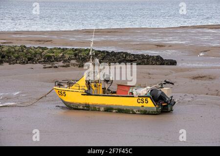 Kleines gelbes Fischerboot am Strand in Morecambe, Lancashire Stockfoto
