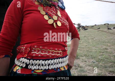 Nomad Frau mit goldener Halskette. Muschelgürtel - Evil Eye. Stockfoto