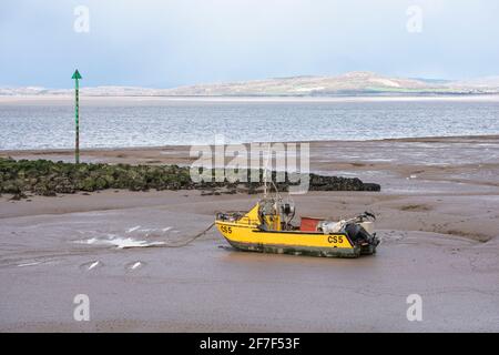 Kleines gelbes Fischerboot am Strand in Morecambe, Lancashire Stockfoto