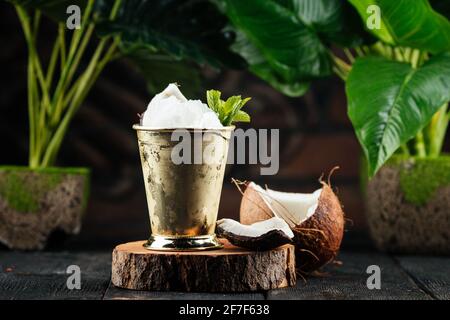 Becher aus Metall mit Kokoseis-Cocktail Stockfoto