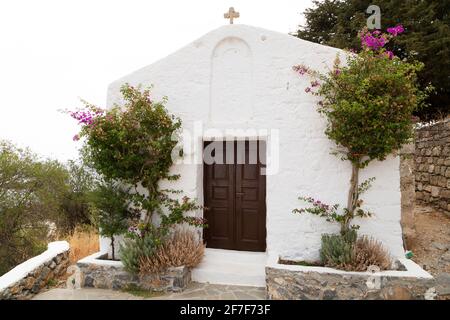 Fassade einer Kapelle auf dem Hügel, die zur Akropolis in Lindos auf Rhodos, Griechenland führt. In der Kapelle wird das griechisch-orthodoxe christentum praktiziert. Stockfoto