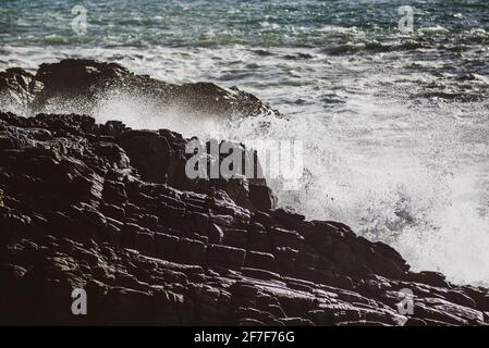 Wellen schlagen an der felsigen Küste Frankreichs. Felsige Küstenlandschaft. Stockfoto