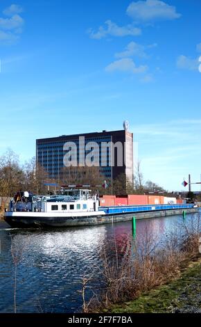 Wolfsburg, 21. Februar 2021: Frachtschiff mit Containern auf dem Kanal vor dem Verwaltungsgebäude der Volkswagen-Autofabrik in Stockfoto