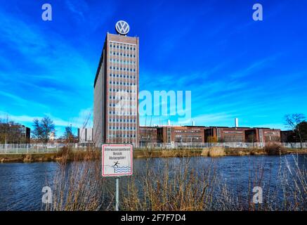 Wolfsburg, 21. Februar 2021: Schild mit deutscher Aufschrift, Sturzgefahr, vor dem VW-Verwaltungsgebäude hinter einem Kanal Stockfoto