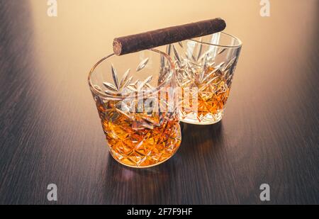 Whiskey in Gläsern und Zigarre auf braunem Holzhintergrund Stockfoto