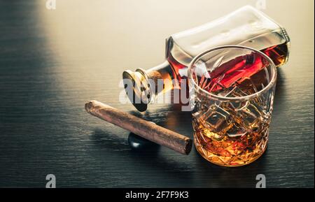 Alkoholisches Getränk, Whiskey und Zigarre auf braunem Holzhintergrund Stockfoto