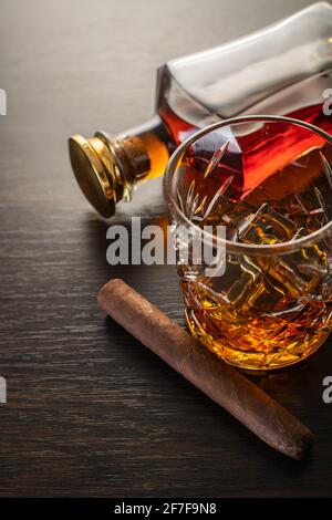 Alkoholisches Getränk, Whiskey und Zigarre auf braunem Holzhintergrund Stockfoto