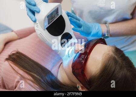 Nahaufnahme einer Frau, die professionelle Zähne bekommt Aufhellung in der Klinik Stockfoto