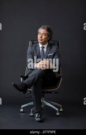 Zuversichtlich Geschäftsmann auf Stuhl sitzend Stockfoto