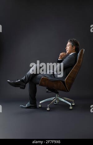 Zuversichtlich Geschäftsmann auf Stuhl sitzend Stockfoto