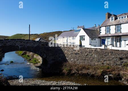 Aberdaron Village, Wales. Kleine, charmante Steinbrücke über einen Bach. Seitenansicht im Landscape-Format. Blauer Himmel und Kopierbereich. Stockfoto