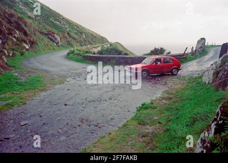 Ein Auto, das durch eine Straße fährt, die über eine Straße fließt, September 1990, Dingle Peninsula, Co. Kerry, Irland Stockfoto