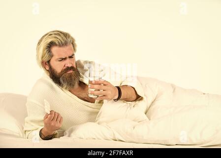 Hipster trinken Wasser Nehmen Sie Medikamente. Kopfschmerz Kater. Kater-Heilmittel. Überschlafen kann Körper ein Risiko für metabolische Probleme setzen. Kater-Konzept. Mann Stockfoto