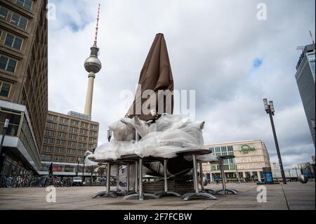 Berlin, Deutschland. April 2021. Tische und Stühle sind vor einem Café am Alexanderplatz eingepackt. Die Restaurants und Bars sind wegen des Corona-Virus immer noch geschlossen. Quelle: Christophe Gateau/dpa/Alamy Live News Stockfoto