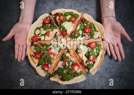 Pizza mit Käse, Tomaten, Spinat und Räucherwurst Stockfoto