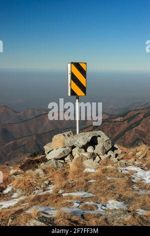 Straßenbegrenzer scherzhaft auf der Spitze eines hohen montiert Berg Stockfoto