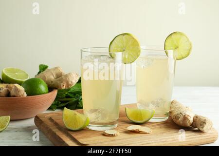 Gläser Ingwerbier und Zutaten auf weißem Holztisch Stockfoto