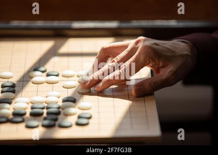Älterer Mann, der das Spiel GO spielt Stockfoto