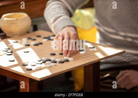 Junger Mann spielt das Spiel GO Stockfoto