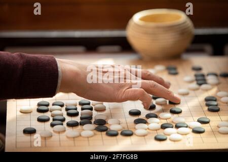Älterer Mann, der das Spiel GO spielt Stockfoto