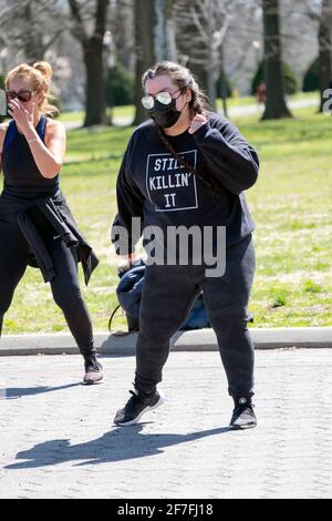 Eine Frau mit Zöpfen und einem „STILL KILLIN“ IT-Sweatshirt nimmt an einem kräftigen Zumba-Tanzkurs in Queens, New York City, Teil. Stockfoto