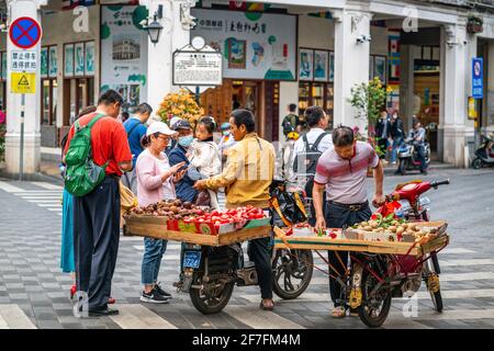 Haikou China , 21 March 2021 : Chinesische Touristen kaufen exotische Früchte von lokalen Völkern Falken in der Straße der Haikou Altstadt Hainan China Stockfoto