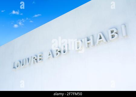 Abu Dhabi, VAE - 27. März 2018: Der Name des Museums an der weißen Wand im Louvre Abu Dhabi Haupteingang, Saadiyat Insel Stockfoto