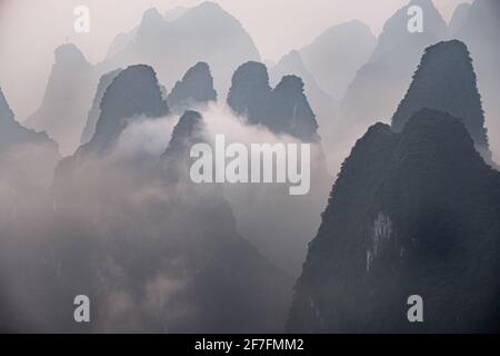 Nebliger Morgen mit Nebel und niedrigen Wolken auf den Gipfeln über dem Fluss Li, Guangxi, China, Asien Stockfoto