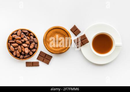 Kakaobohnen und Pulver mit heißer Schokolade in weißer Tasse. Draufsicht, flach liegend Stockfoto