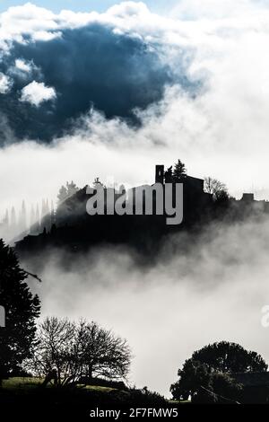 Das Dorf Montefioralle wurde im Morgennebel, als die Sonne durchbricht, in der Toskana, Italien, Europa, umhüllt Stockfoto