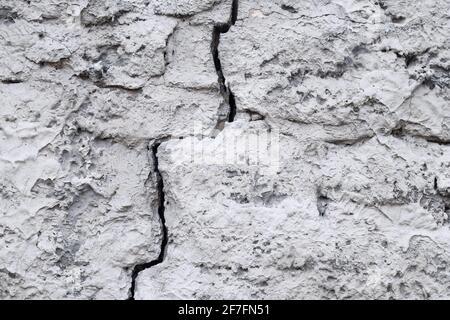 Rissige Betonwand, graue Grunge-Textur. Zerstörter Zement alte Wand, abstrakter Hintergrund. Rissfläche. Schäden an defekten Gebäuden verschlissen. Gefahr von c Stockfoto
