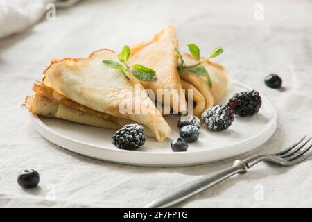 Leckere traditionelle russische Pfannkuchen auf weißer Tischdecke. Pfannkuchen Woche. Shrovetide. Nahaufnahme. Stockfoto