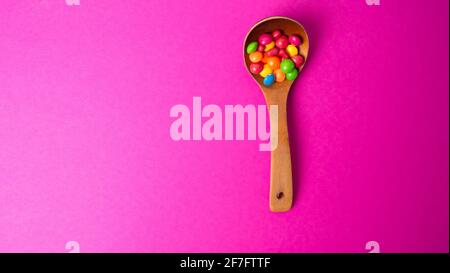 Mehrfarbiges Bonbon-Set mit einem Holzlöffel Stockfoto