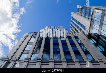 Teil eines hohen modernen Bürogebäudes aus Glas und Beton gegen den bewölkten Himmel. Stockfoto